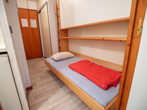 A single-bed room with a wooden bunk bed, a white door, and a small white appliance in the corner. - Studio with national park view - 3 guests (Valfréjus)
