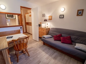 A compact living space with a kitchenette, a dining area, and a sofa. - Studio with national park view - 3 guests (Valfréjus)