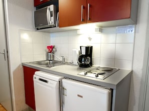 A compact kitchen with a microwave, coffee maker, and a dishwasher. - Mountain-style apartment, pets welcome - 4 guests (Villarodin-Bourget)