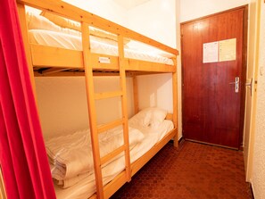 A bunk bed room with a wooden ladder, a door with a notice, and a tiled floor. - Ideal studio slopeside, pets welcome - 4 guests (Villarodin-Bourget)
