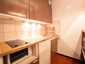 A compact kitchen with a built-in oven, a sink, and a microwave. - Ideal studio slopeside, pets welcome - 4 guests (Villarodin-Bourget)