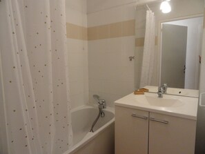 A bathroom with a bathtub, a sink, and a mirror. - Spacious apartment mountain view - 10 guests (Villarodin-Bourget)