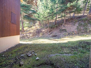 A wooden building with a dirt path leading to a grassy area with scattered rocks. - Cozy apartment, pets welcome - 4 guests (Villarodin-Bourget)