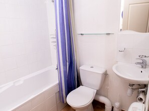 Ein Badezimmer mit Badewanne, Toilette und Waschbecken.