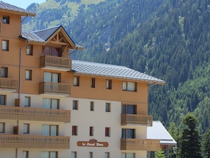 A multi-story hotel with balconies and a sign reading 'Le Cheval Blanc'. - Spacious apartment, mountain view - 10 guests (Valfréjus)