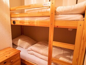 A bunk bed with a wooden frame and a small wooden nightstand beside it. - Studio, pets allowed - Park view 4 guests (Villarodin-Bourget)