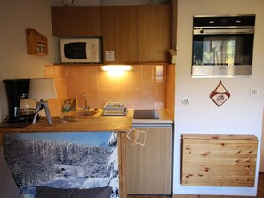 A compact kitchen with a microwave, oven, and sink. - Studio, pets allowed - Park view 4 guests (Villarodin-Bourget)
