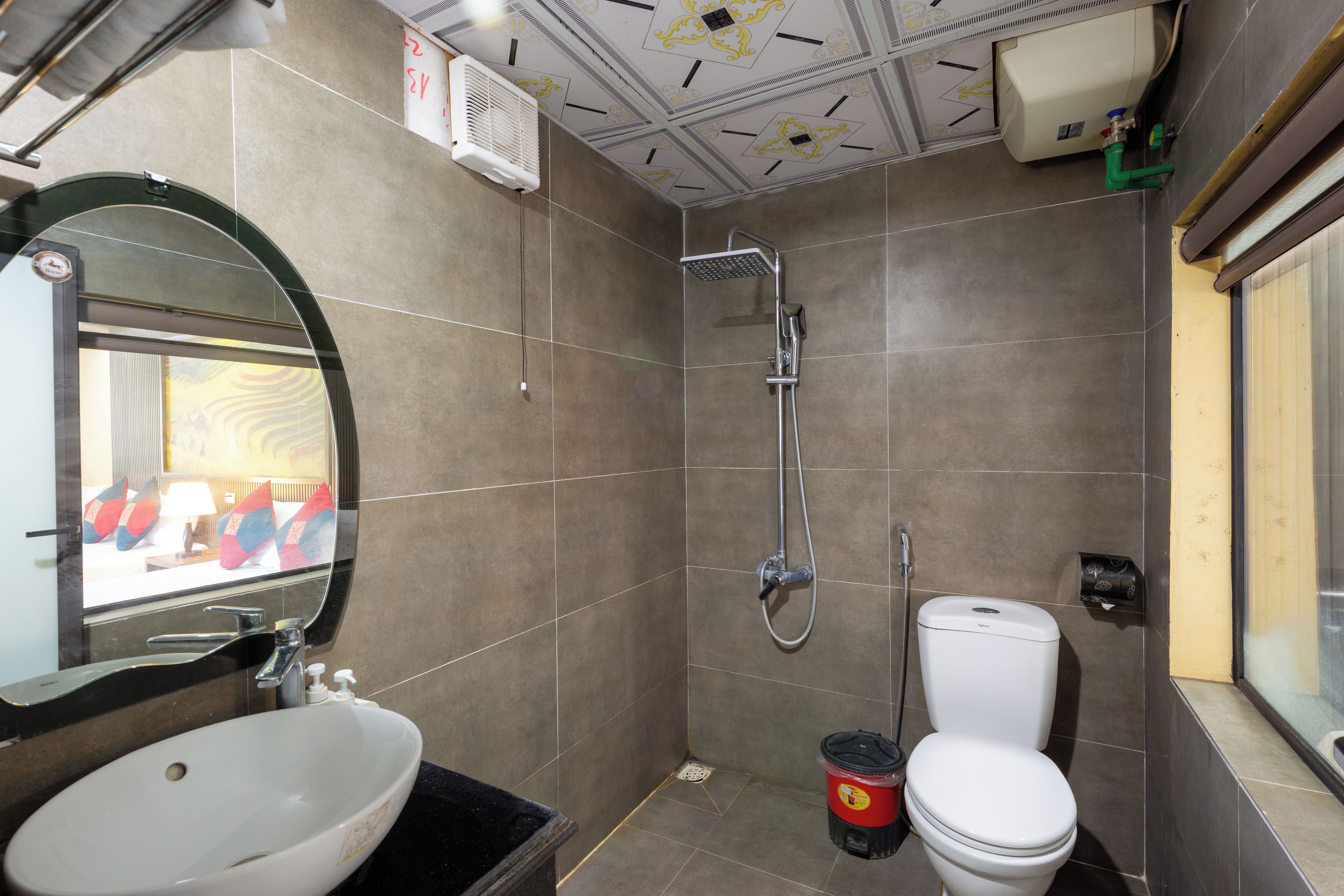 Ein Badezimmer mit Dusche, Toilette, Waschbecken und Spiegel.