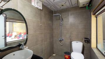 Ein Badezimmer mit Dusche, Toilette, Waschbecken und Spiegel.