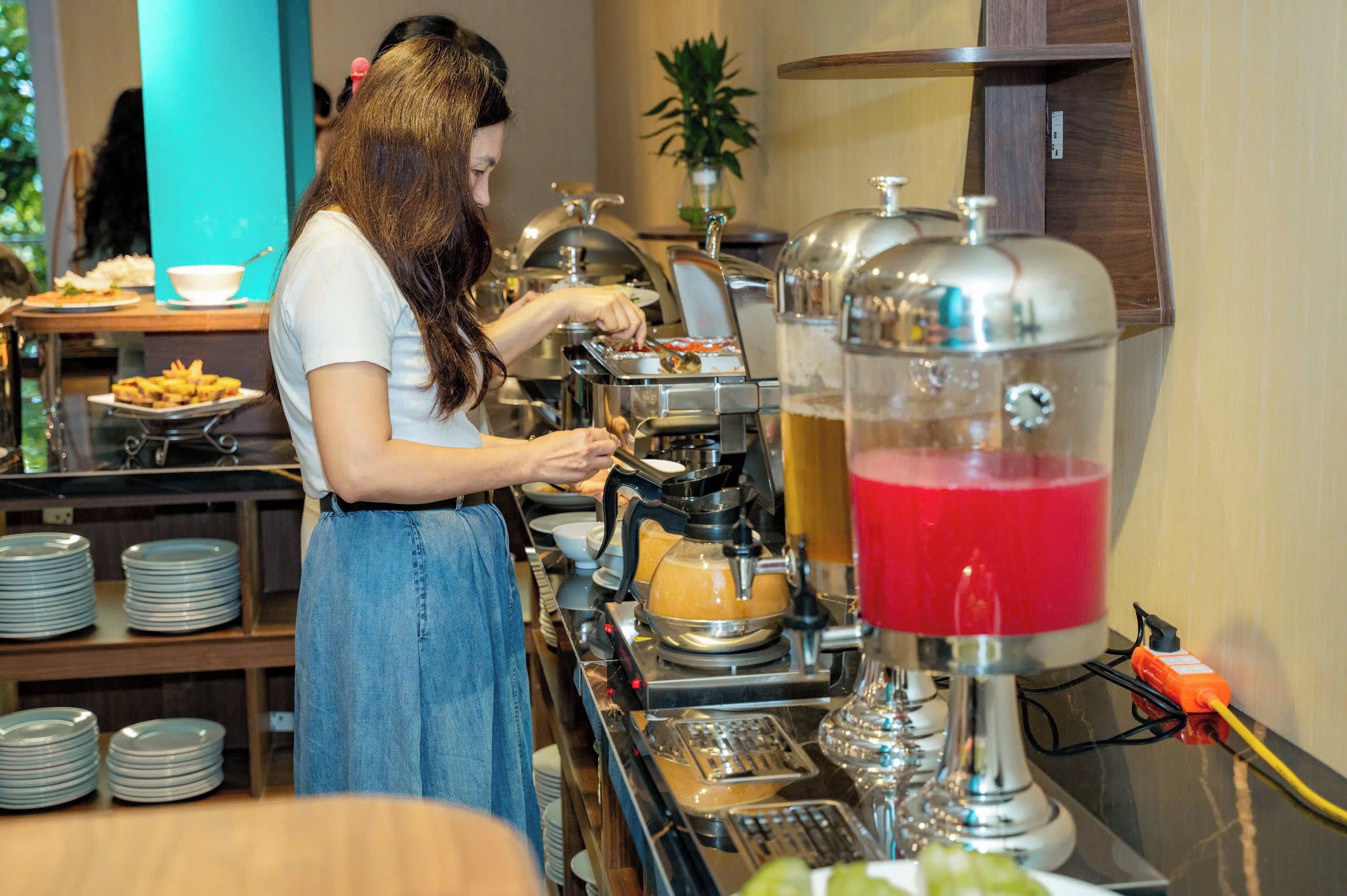A buffet setup with a beverage dispenser and food items.