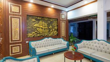 A room with a large mural, two sofas, and a coffee table.