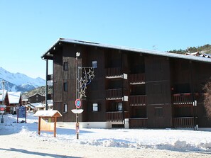 Un edificio in legno con balconi, un segnale di divieto di parcheggio e una targa in legno.
