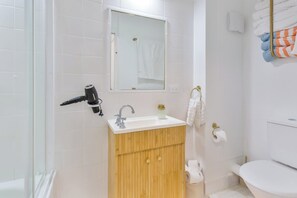 A bathroom with a white sink, wooden vanity, a mirror, a towel rack, and a toilet. - Aloha Bliss Surfers Paradise Beach Stay (Surfers Paradise)