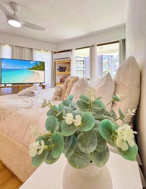 A hotel room with a bed, a television, a ceiling fan, and a view of the beach. - Aloha Bliss Surfers Paradise Beach Stay (Surfers Paradise)