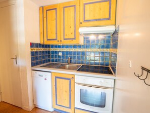 A compact kitchen with wooden cabinets, a built-in oven, and a dishwasher. - Spacious apartment at the foot of the slopes - 8 guests (Villarodin-Bourget)
