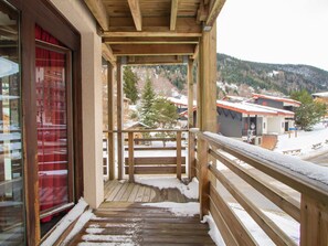 A wooden balcony with a view of a snowy landscape and buildings. - Apartment pets OK - 6 guests (village view) (Villarodin-Bourget)