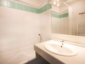 Ein Badezimmer mit Waschbecken, Spiegel und Dusche.