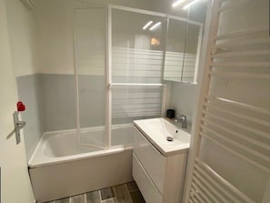 A bathroom with a bathtub, a sink, and a mirror. - Practical apartment, slopes view - 5 guests (Arette)