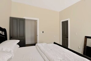 Una habitación de hotel con una cama, un armario y un espejo.