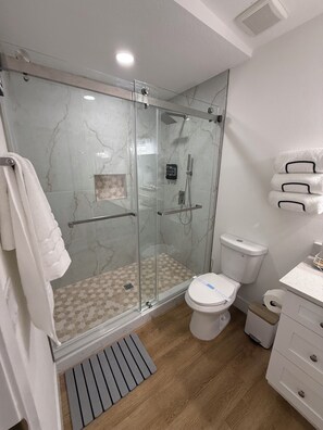 Kylpyhuoneessa on lasiseinällä varustettu suihku, wc, pesuallas ja pyyheteline.