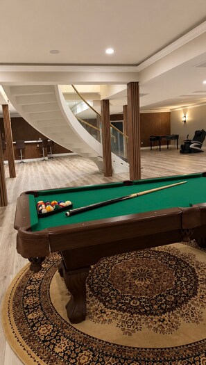 A pool table with balls, a patterned carpet, and a staircase with a railing. - Entire home in Aldie, Virginia, United States (Aldie)