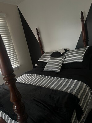 A bedroom with a bed, wooden headboard, and striped bedding. - The Chesterfield House: Luxury Caribbean Escape in Barbados (St. Michael, M10)