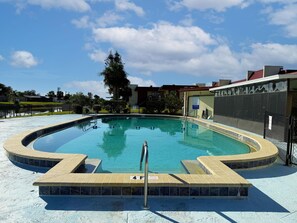 A circular pool with a tiled edge and a metal ladder leading into the water. - 2BR Riverhouse Condo – Pools, Golf & Beaches (Rotonda West)