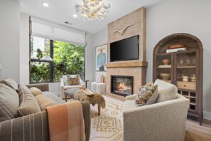 A living room with a fireplace, comfortable seating, and a television. - Stunning Home on Music Row - Rooftop TV, Sauna, & Grill Near Broadway! (Nashville)