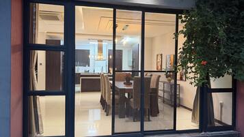 Un interno moderno con zona pranzo, cucina e un'ampia porta-finestra scorrevole che si apre su un balcone.