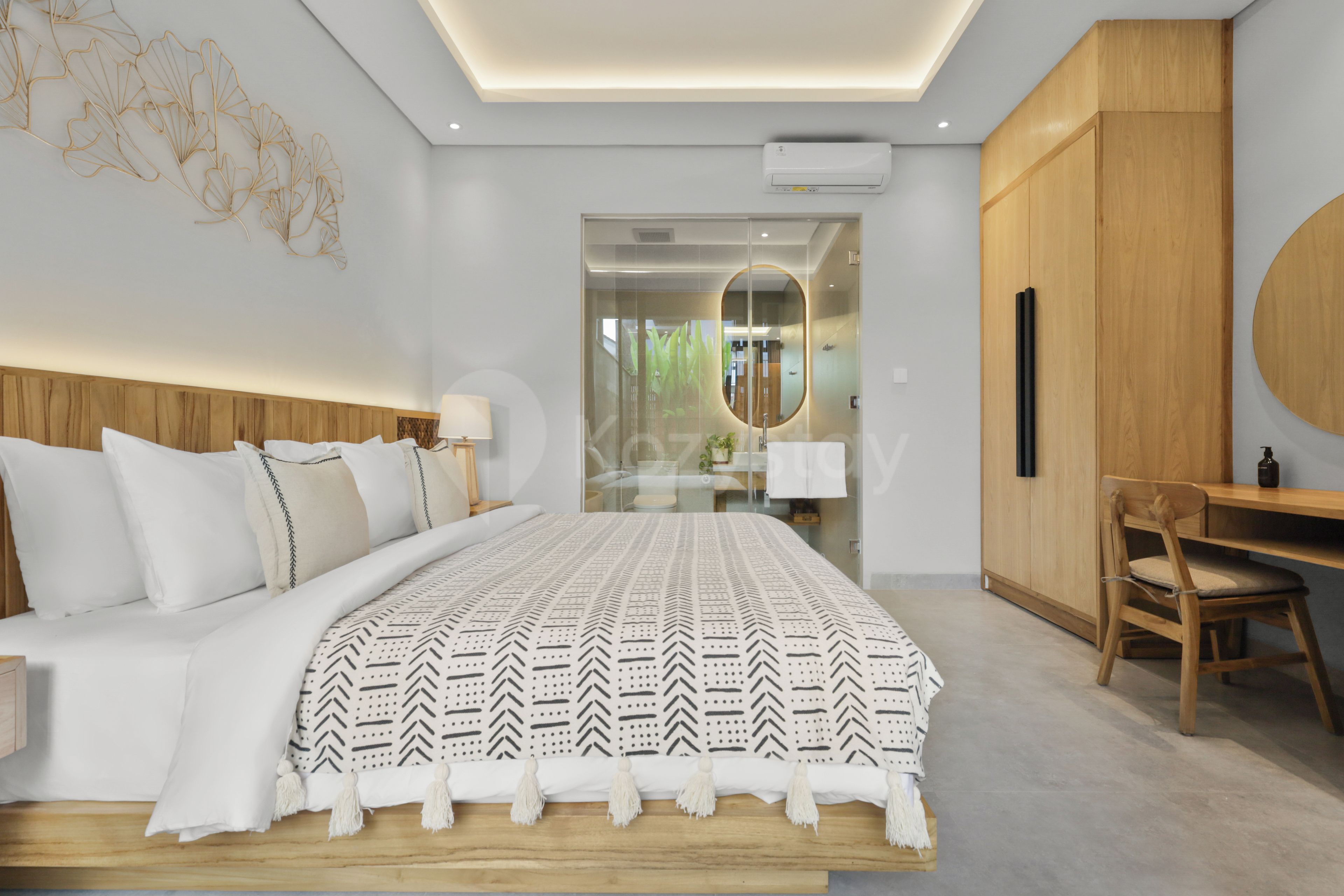 Un dormitorio moderno con una cama grande, cabecera de madera, un escritorio y un armario.
