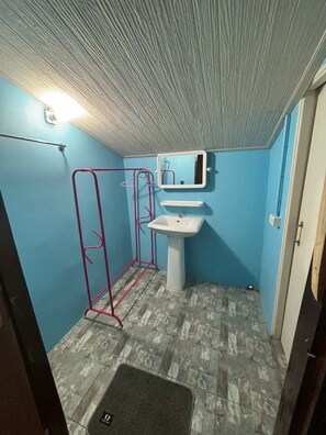 A small bathroom with a white sink, a mirror, and a shower area with a red frame. - khaosoksaengtawanresortandcamp (Phanom)