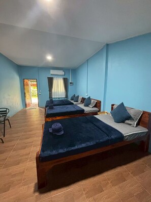 A room with three wooden beds, a chair, and a door leading outside. - khaosoksaengtawanresortandcamp (Phanom)