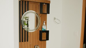 Un baño con tocador de madera, un espejo, un lavabo y un perchero para toallas.
