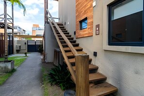Eine Treppe führt zu einem Gebäude mit modernem Design, einem verschlossenen Eingang und blauem Himmel.