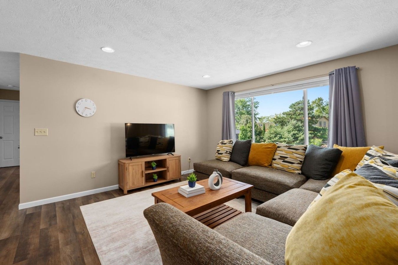 A living room with a television, sofa, and coffee table.