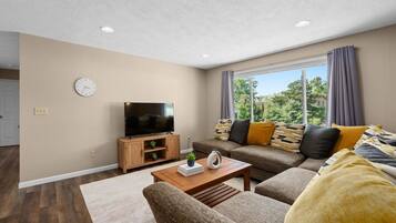 A living room with a television, sofa, and coffee table.