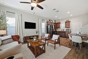 A modern living room with a wooden coffee table, leather armchairs, and a sofa.