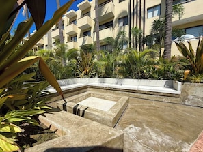 A pool area with a rectangular shape, surrounded by palm trees and plants. - Relax at Oceanna | Rooftop, Jacuzzi, and 3 Pools (Mazatlán)