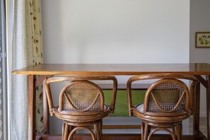 A wooden table with two wicker chairs. - 1BR Tighes Hill Retreat with Private Courtyard (Tighes Hill)