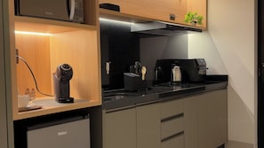 A modern kitchen with a built-in coffee machine, a microwave, and a range hood. - Kaya Parque Sinop (Sinop)