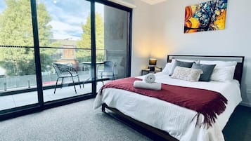 A hotel room with a large sliding glass door leading to an outdoor seating area.