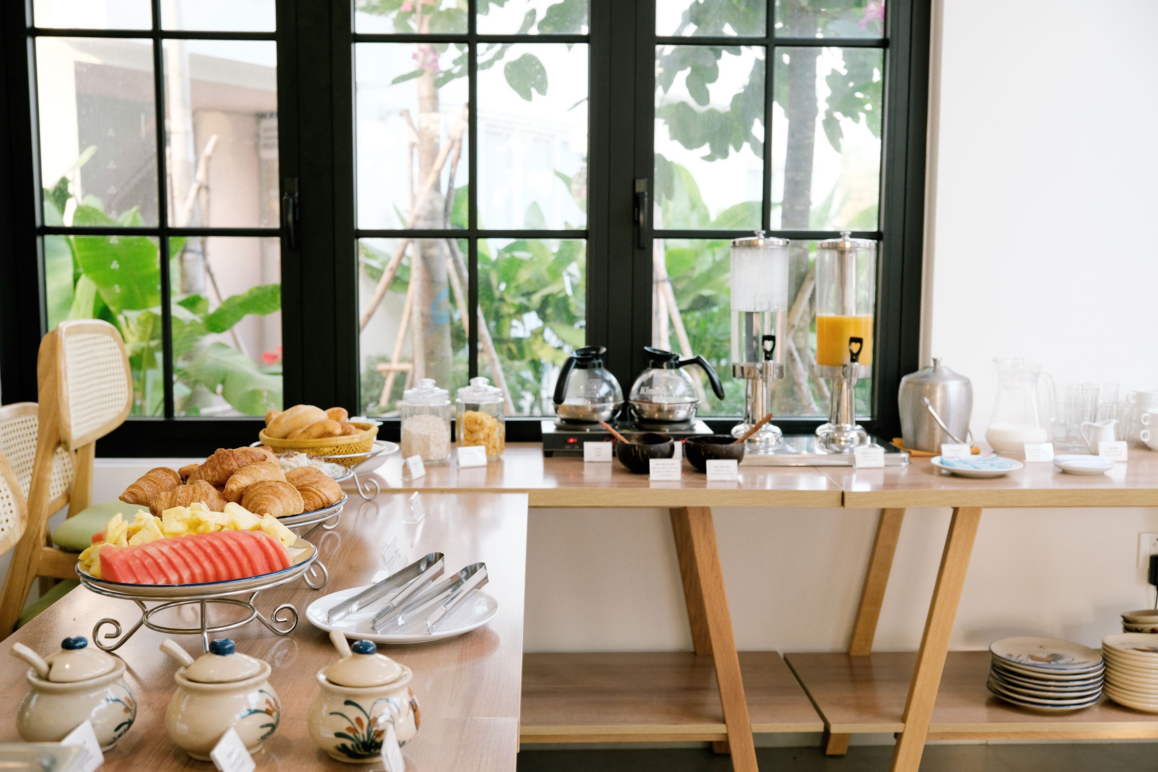 A breakfast buffet with various food items and utensils.
