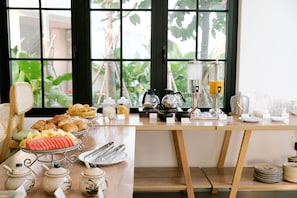 A breakfast buffet with various food items and utensils.