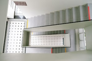 A staircase with a patterned wall and a sign indicating hotel room numbers.