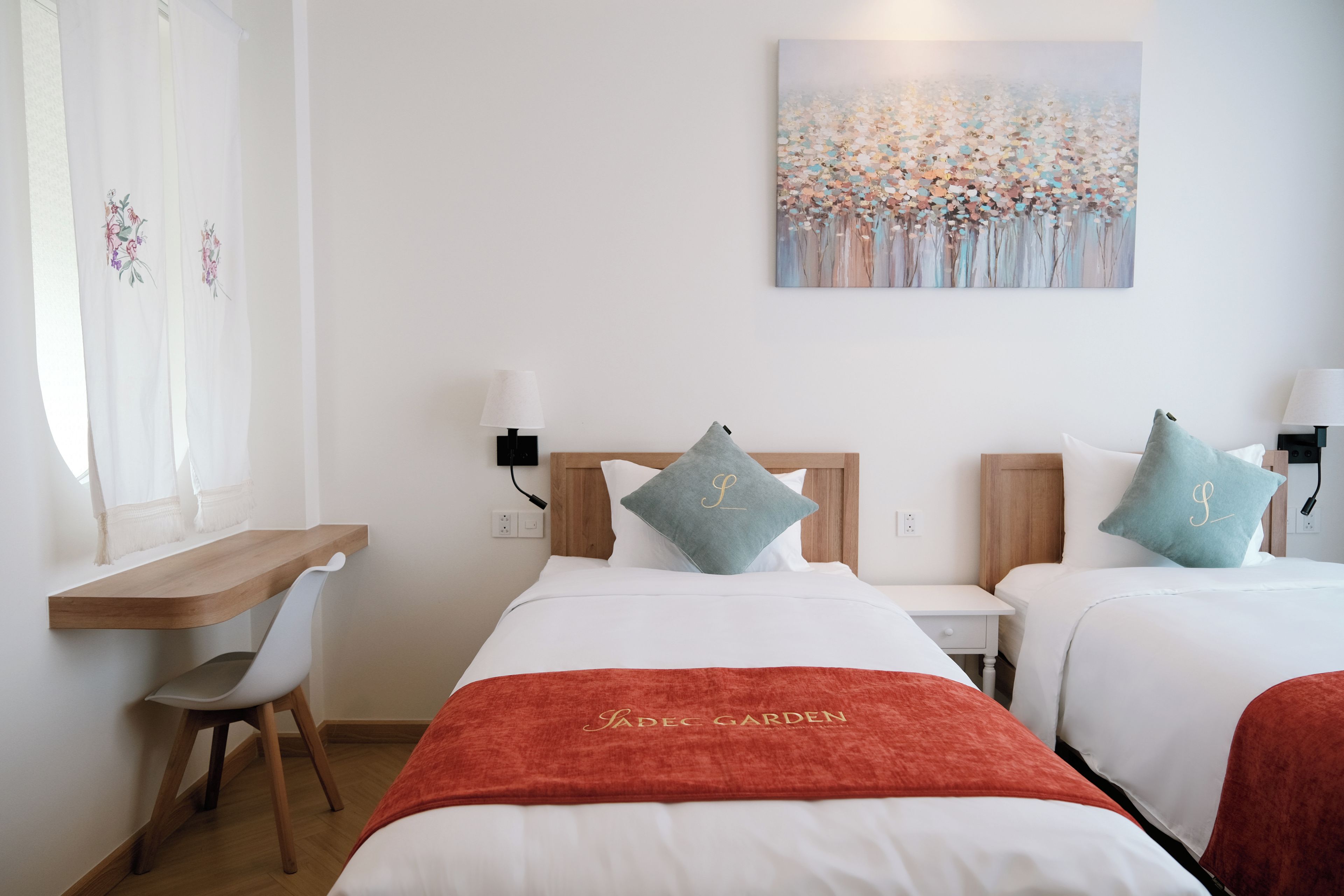 Une chambre d’hôtel avec deux lits, un bureau et une chaise.
