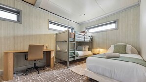 Ein Hotelzimmer mit einem Etagenbett, einem Schreibtisch und einem Stuhl.