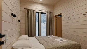 A room with a bed, two pillows, a blanket, and a window with curtains. - Villa QUU C,  Premium 4BD Villa with Sauna (Kolari)
