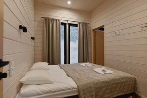 A room with a bed, two pillows, a blanket, and a window with curtains. - Villa QUU C,  Premium 4BD Villa with Sauna (Kolari)