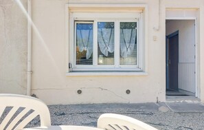 Ein Gebäude mit Fenster, Tür und einem Stuhl vor der Fassade.