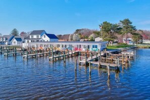 A waterfront property with docked boats, a marina, and residential buildings in the background.